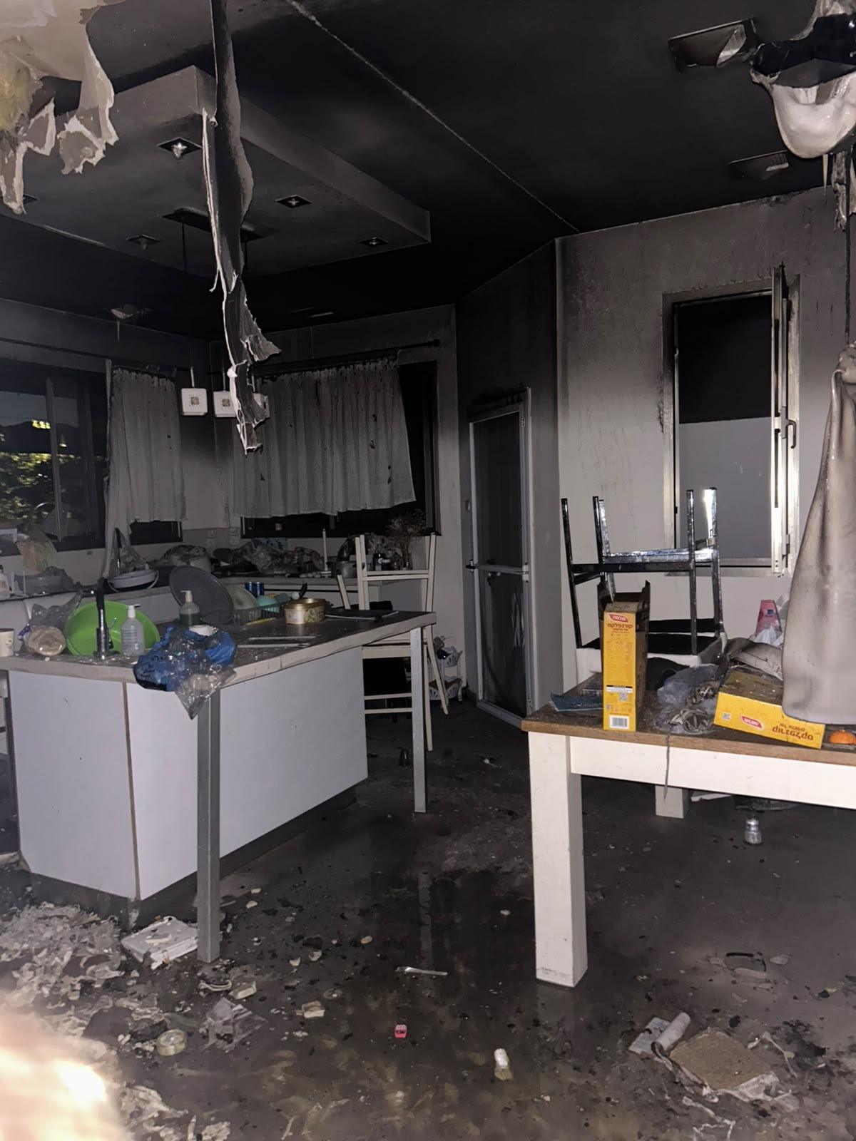 The Kleinman family home after the fire — a charred ceiling and a floor covered in soot and water
